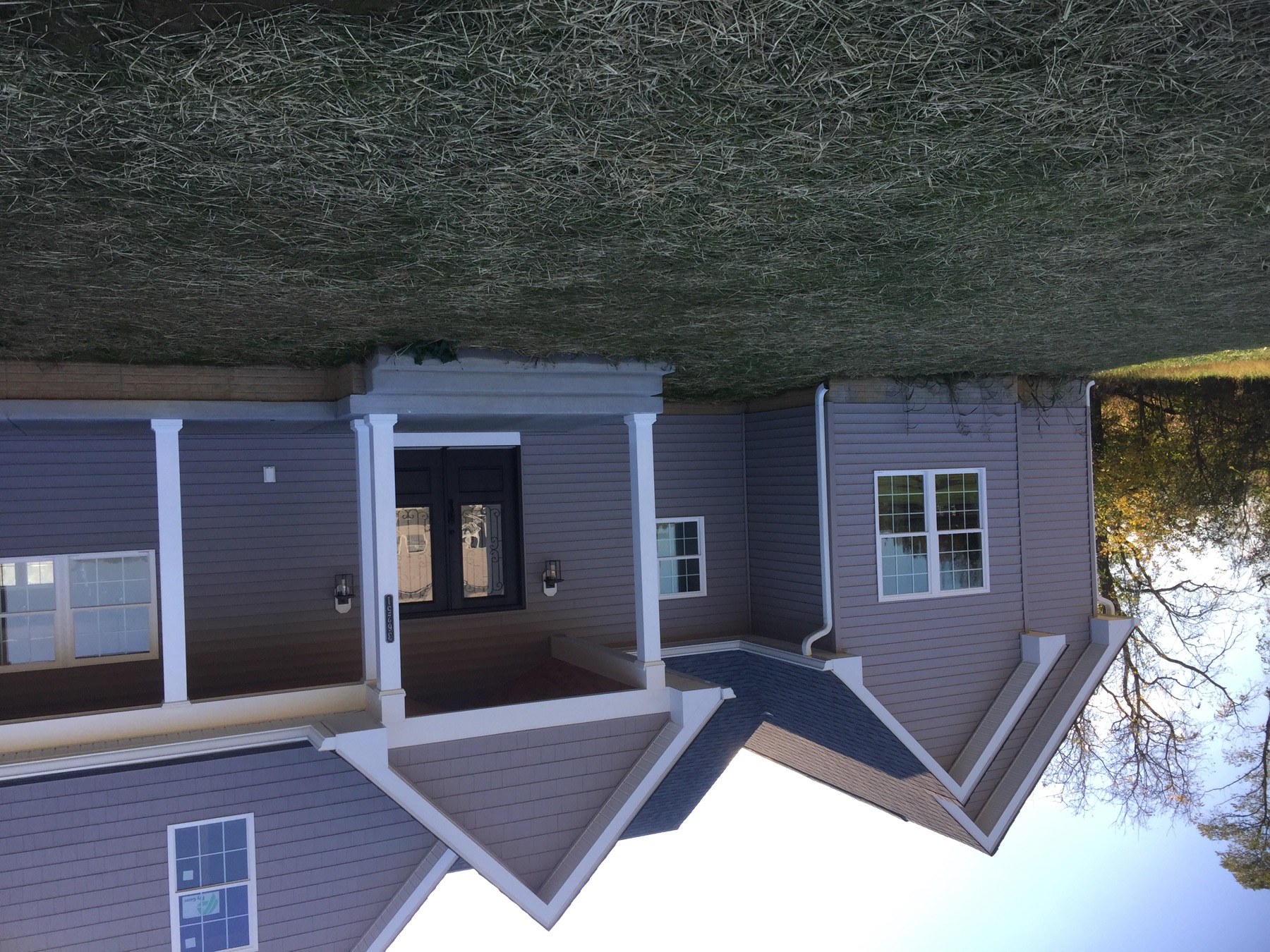 Completed gray custom home with white trim and a covered front porch