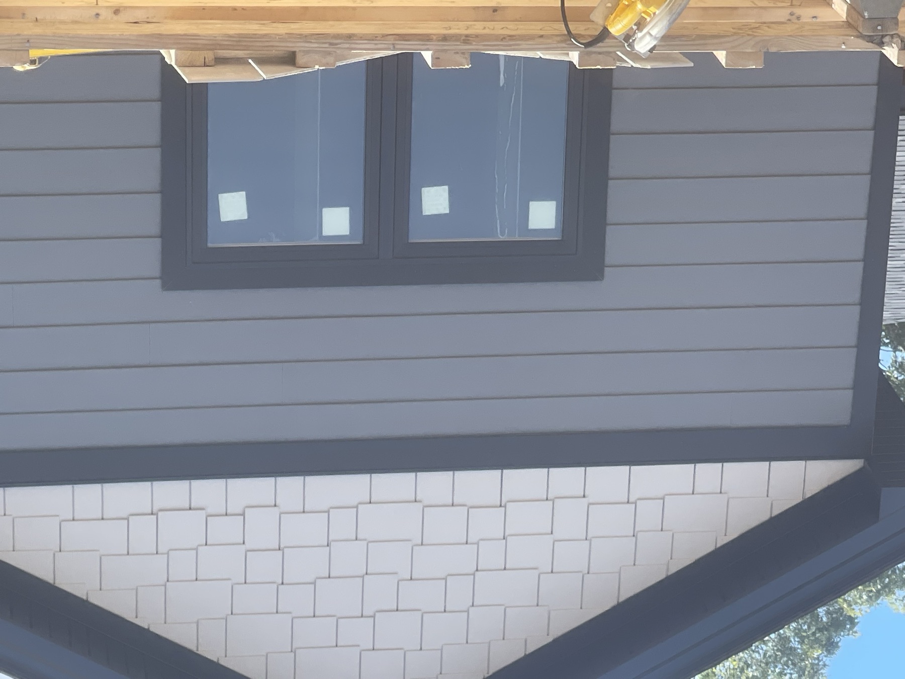 Gray lap siding, white shake siding, and black trim on a custom home exterior