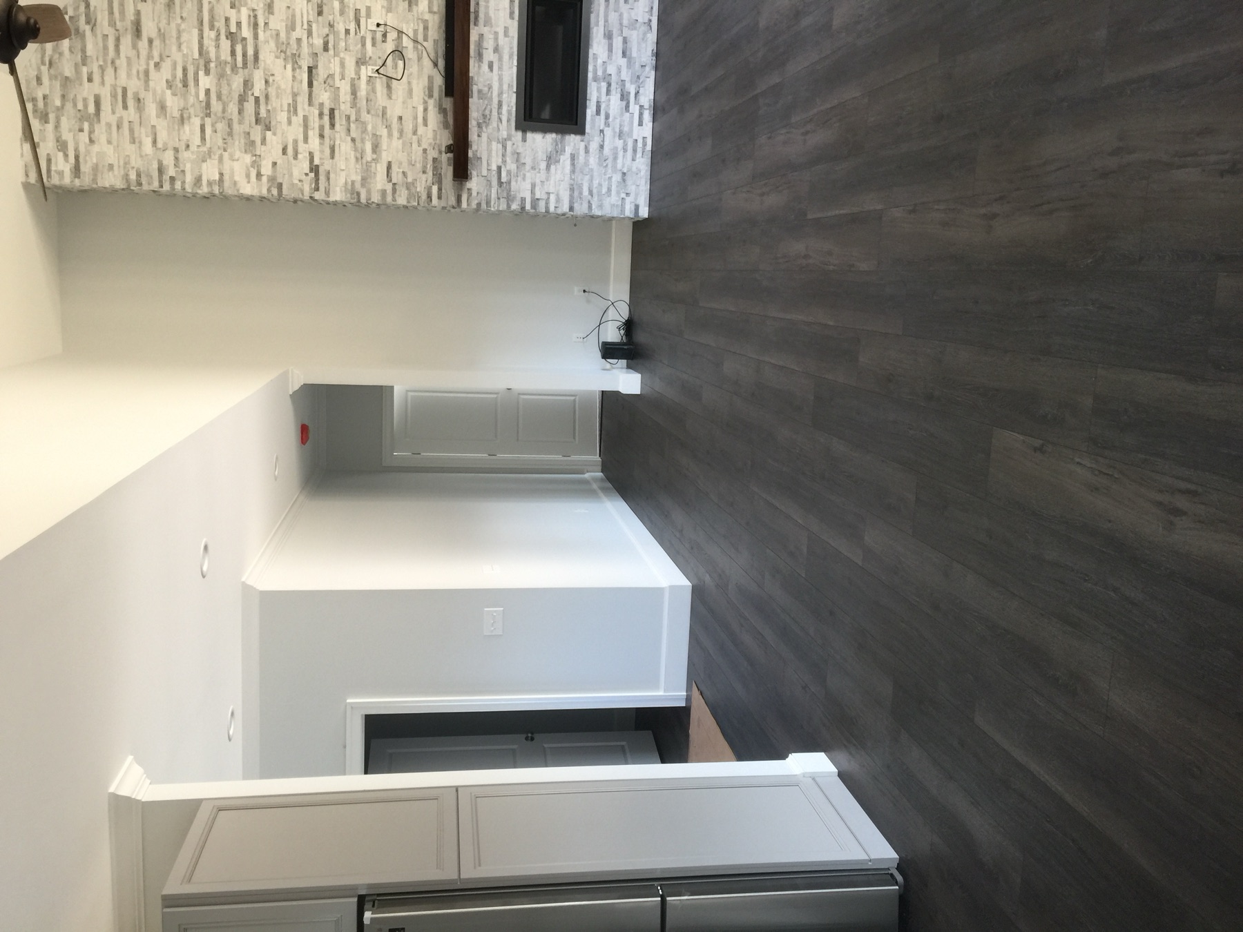 Finished open-plan custom home interior with dark floors and a stone fireplace